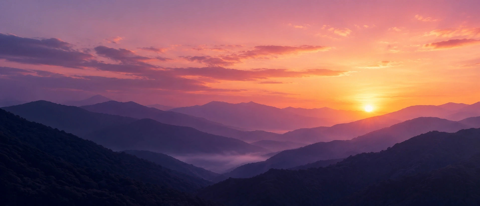 Sunrise over layered mountain ridges